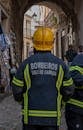 Back view of a firefighter walking through an historic street in Coimbra, Portugal.